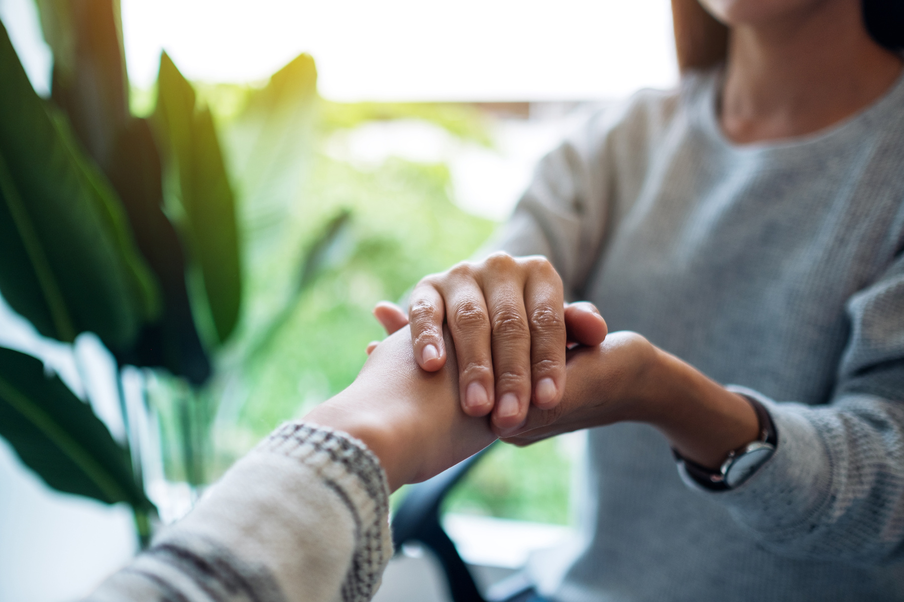 Women Holding Each Other Hands for Comfort and Sympathy